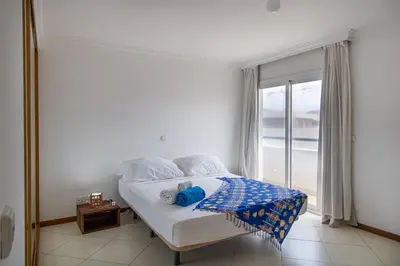 a bedroom with a bed and a window with a view at Sky Mariposa sospesa sul mare in Mindelo