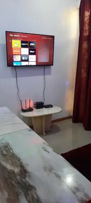 a tv hanging on a wall above a table at My Flat 1 in Praia