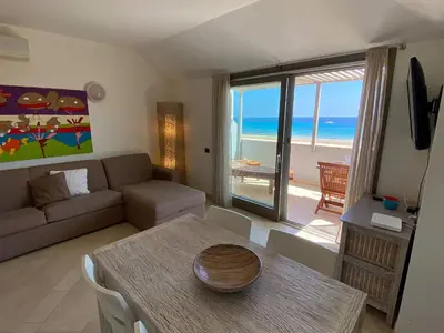 a living room with a couch and a table with a view of the ocean at Corallo Beach Front Apartments - By Bobbywashere in Santa Maria