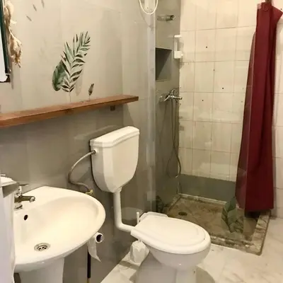 a bathroom with a toilet and a sink and a shower at Syds Beach House in Praia