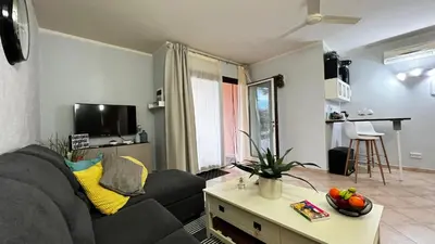 a living room with a black couch and a table at Tropical Morabeza Apartment Santa Maria in Santa Maria