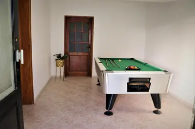 a pool table in a room with a door at Apartamento Mágico p/ momentos Memoráveis in Santa Maria
