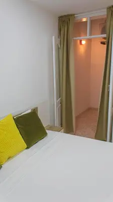 a bedroom with a white bed with a yellow pillow at Apartamento Mágico p/ momentos Memoráveis in Santa Maria