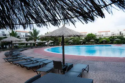 a pool with chairs and umbrellas next to a resort at Casa Cubada in Santa Maria