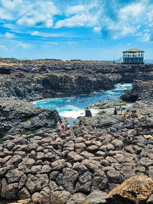 a group of people on a rocky beach near the ocean at Casa Cubada in Santa Maria