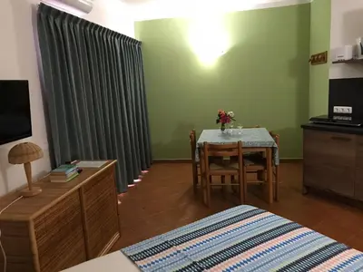 a bedroom with a table and a room with a bed at studio's Porto Antigo 2 in Santa Maria