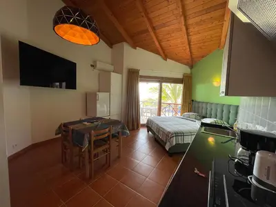 a room with a kitchen and a bed and a table at studio's Porto Antigo 2 in Santa Maria