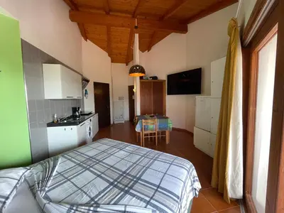a bedroom with a bed and a kitchen with a table at studio's Porto Antigo 2 in Santa Maria