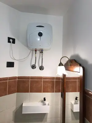 a bathroom with a sink and a camera on the wall at studio's Porto Antigo 2 in Santa Maria