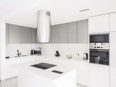 a white kitchen with white cabinets and appliances at Filomena Apartments BOHÈME in Mindelo