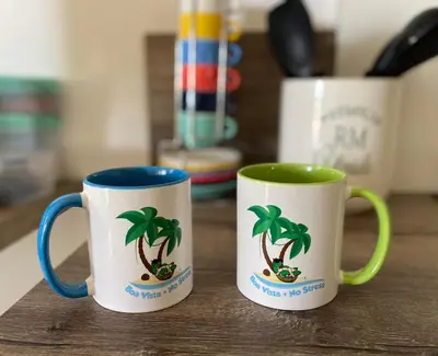 two mugs with palm trees on them sitting on a table at Vila Mare - Praia de Chaves frontline in Cabeçadas