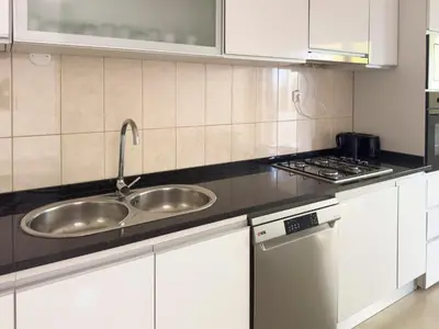 a kitchen with a sink and a stove at 3 bedroom apt, FREE WIFI & AC, Cidadela - LCGR in Praia