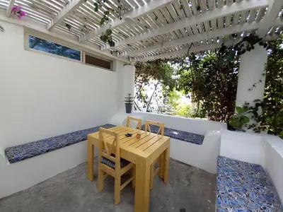 a table and chairs on a patio with a pergola at Praia de Chaves Bungalow ,Boavista in Sal Rei