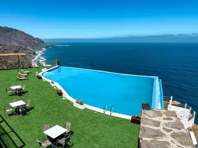 a swimming pool with a view of the ocean at RM Green Hotel in Lombo Branco