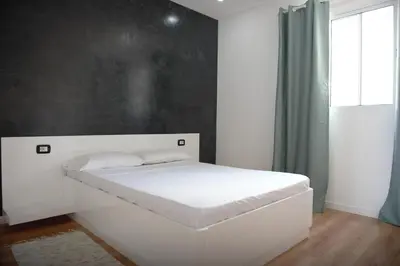 a white bed in a room with a window at Duarte Apartments - Vista in Mindelo