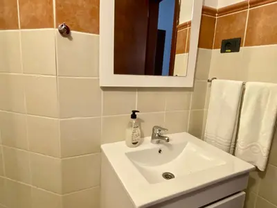 a bathroom with a sink and a mirror and towels at Porto Antigo 2 - By Bobbywashere in Santa Maria