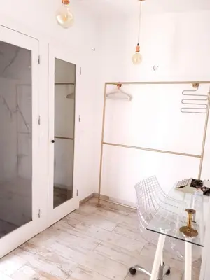a room with a glass table and a mirror at As Hortênsias in Mindelo