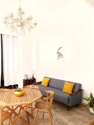 a living room with a blue couch and a table at As Hortênsias in Mindelo