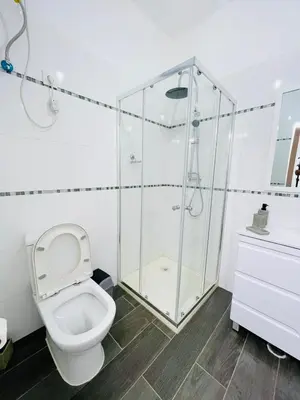 a bathroom with a toilet and a glass shower at Résidence Cazino Apartamentos in Praia