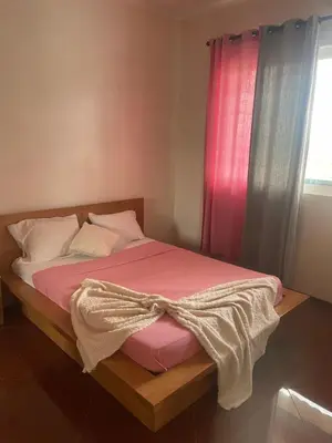 a bedroom with a bed with pink sheets and a window at Tarrafal House in Tarrafal