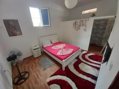 a bedroom with a pink bed and a red rug at Tarrafal House in Tarrafal