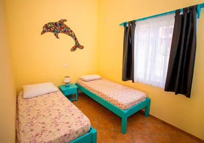 a bedroom with two beds and a dinosaur wall art at Villa Atum. Stella Maris Exclusive in Vila do Maio