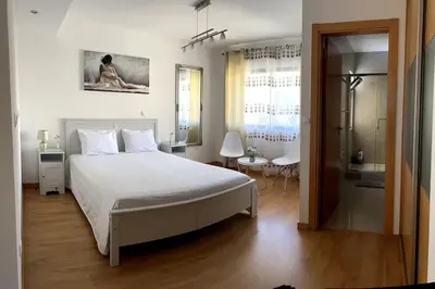 a bedroom with a white bed and a bathroom at Casa So Morabeza in Mindelo