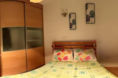 a bedroom with a bed and a wooden cabinet at Casa So Morabeza in Mindelo