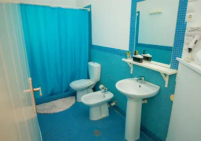a blue bathroom with a toilet and a sink at Appartamento Buzio. Stella Maris Exclusive in Vila do Maio