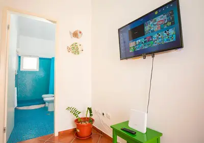 a bathroom with a television hanging on the wall at Appartamento Buzio. Stella Maris Exclusive in Vila do Maio