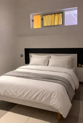 a bedroom with a large white bed with two windows at Casa Chiquinha in Ribeira da Prata