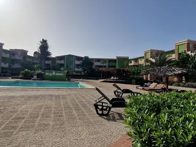 a courtyard with benches and a pool and buildings at Djadsal Moradias in Santa Maria