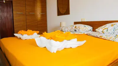 a bed with yellow and white towels on it at Djadsal Moradias in Santa Maria