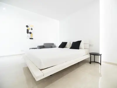 a white bed with black pillows on it in a room at Apartment Sunset in Mindelo
